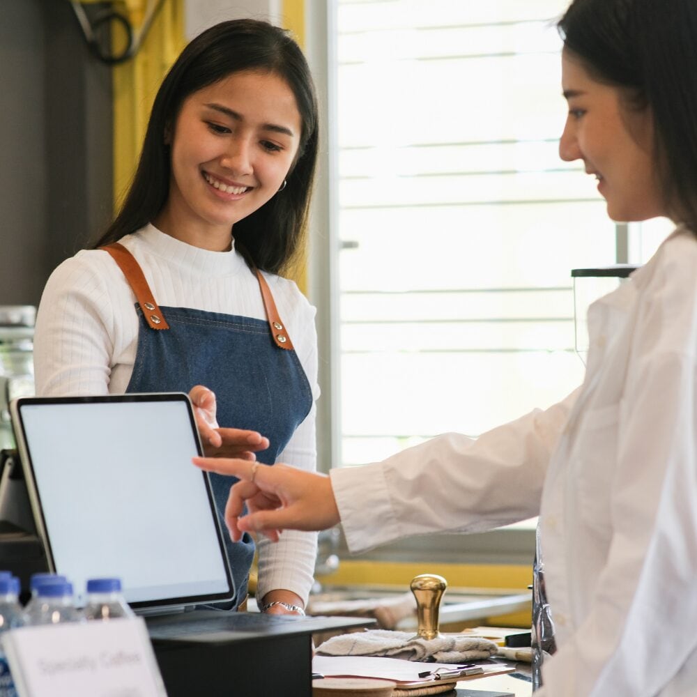 Duena revisando ventas en una tableta en el mostrador